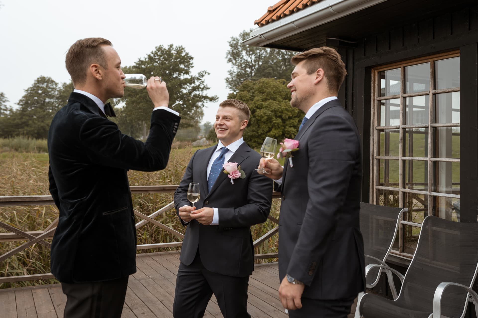 Brudgummen skålar med sina vänner utanför stugan – bröllopsfoto av Mehmet Budak