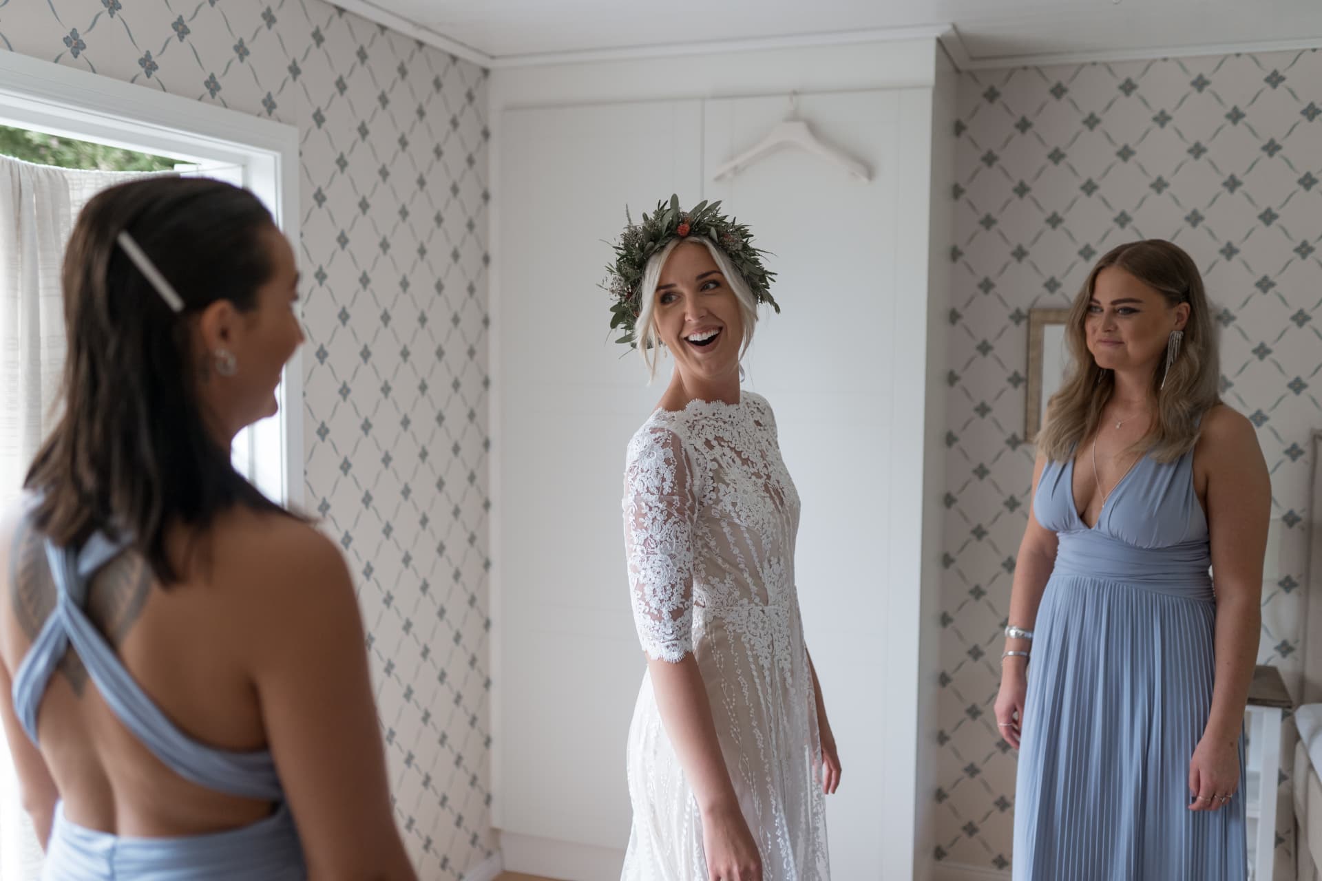Bruden skrattar i klänning och blomsterkrans med tärnorna – bröllopsfoto av Mehmet Budak