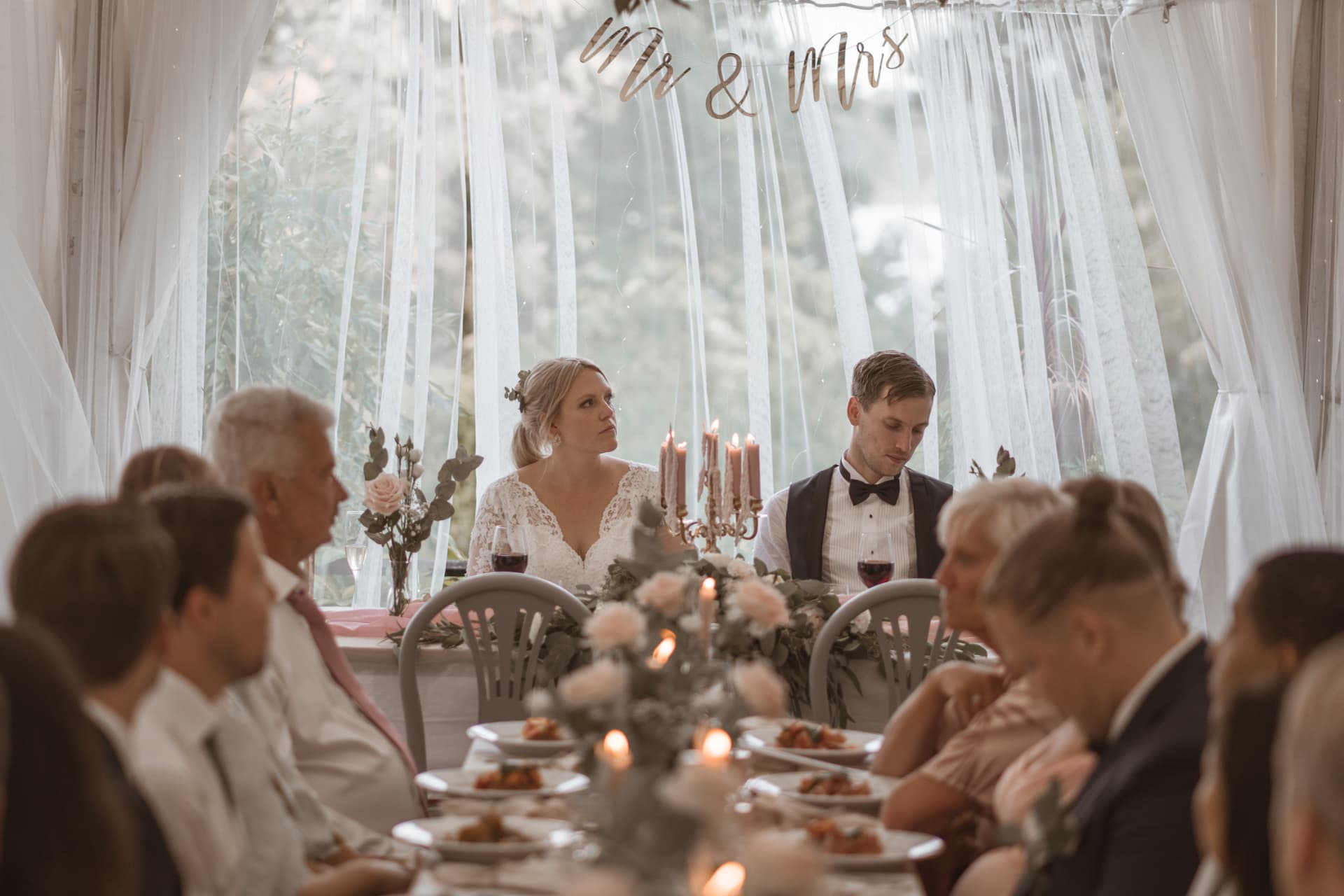 Brudparet vid honnörsbordet under Mr & Mrs-skylten – bröllopsfoto av Mehmet Budak