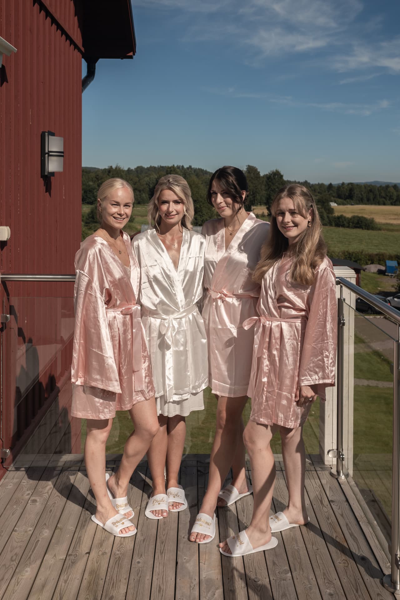 Bruden och tärnorna i morgonrockar på altanen vid Ulvsunda Herrgård – bröllopsfoto av Mehmet Budak