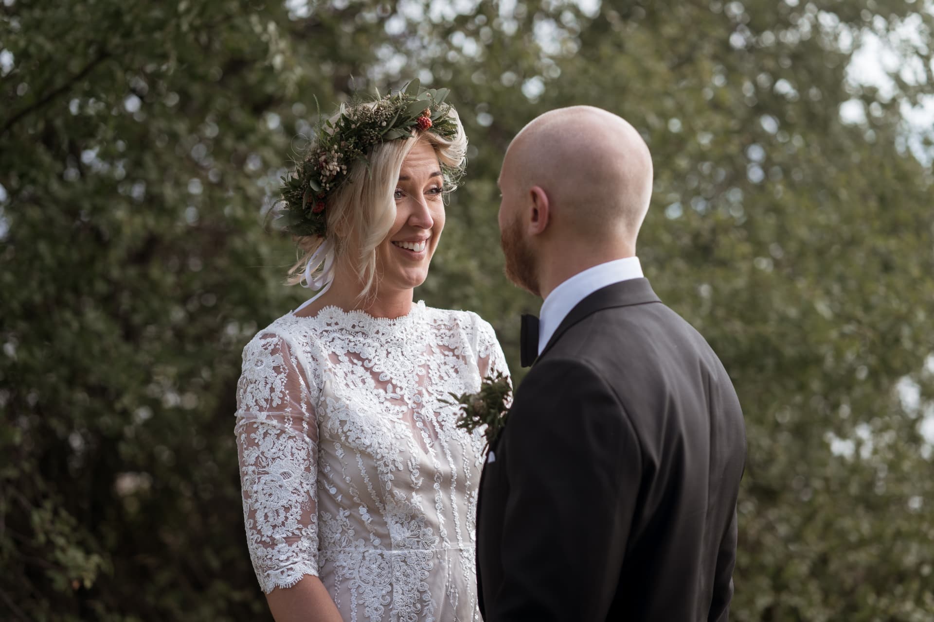 Närbild på bruden i blomsterkrans som ser på brudgummen – bröllopsfoto av Mehmet Budak