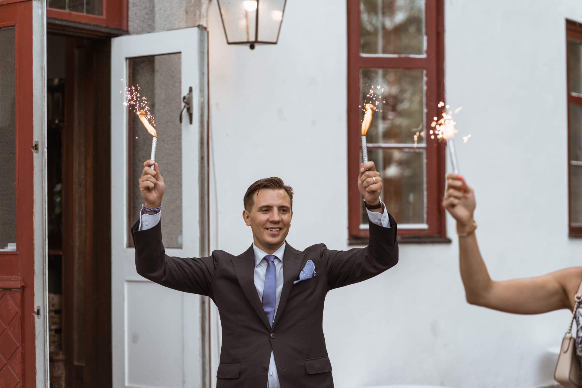 En gäst höjer tärtbloss vid ingången till festen – bröllopsfoto av Mehmet Budak
