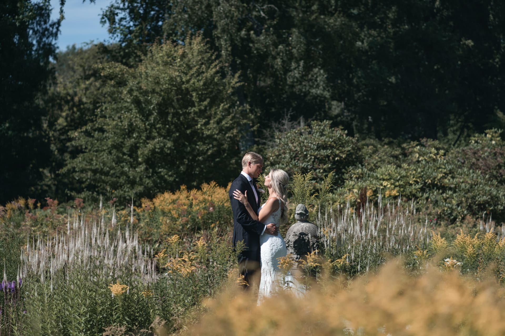 Brudparet panna mot panna i den blomstrande herrgårdsparken – bröllopsfoto av Mehmet Budak