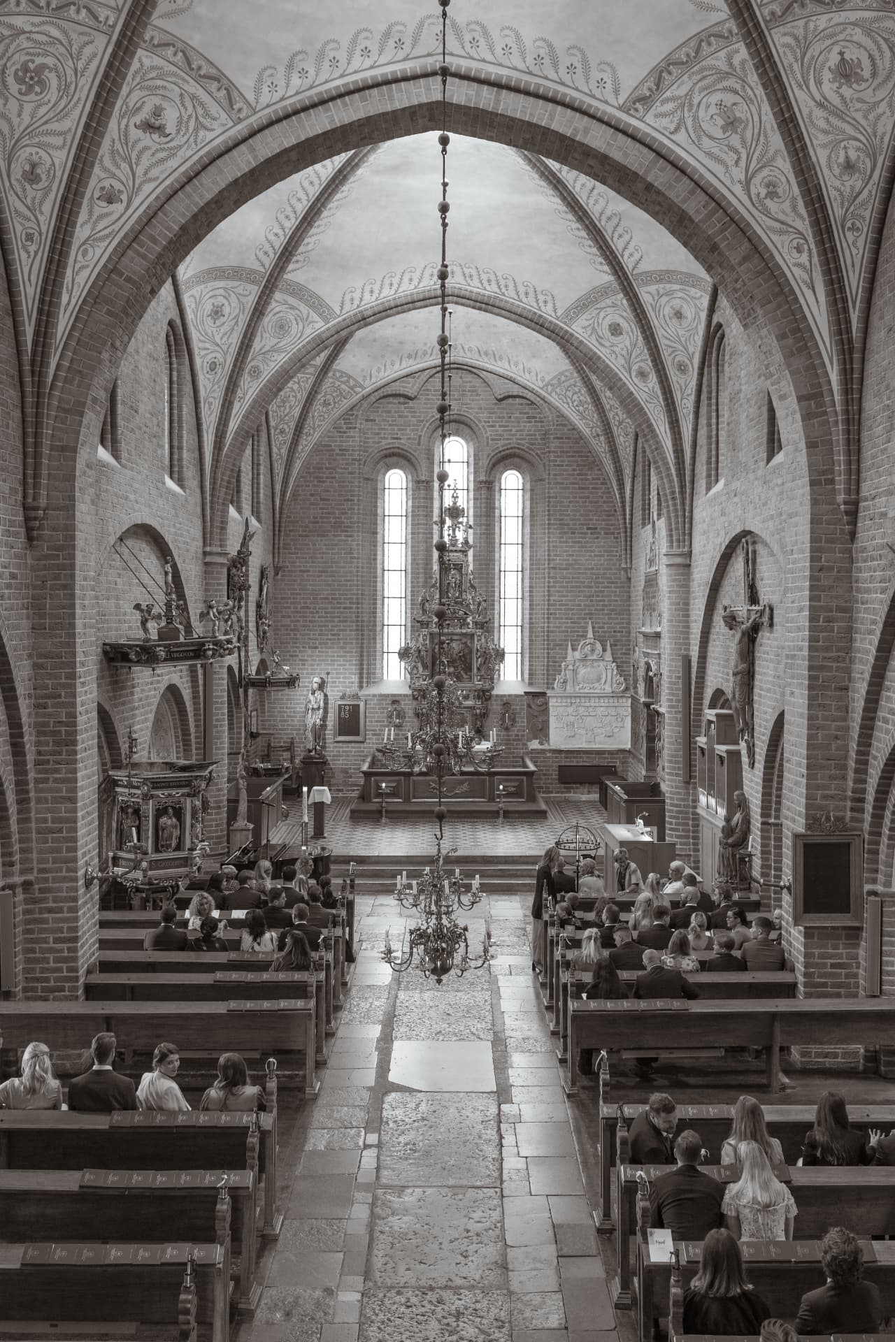 Vigseln sedd från läktaren genom kyrkans valv, sepiaton – bröllopsfoto av Mehmet Budak