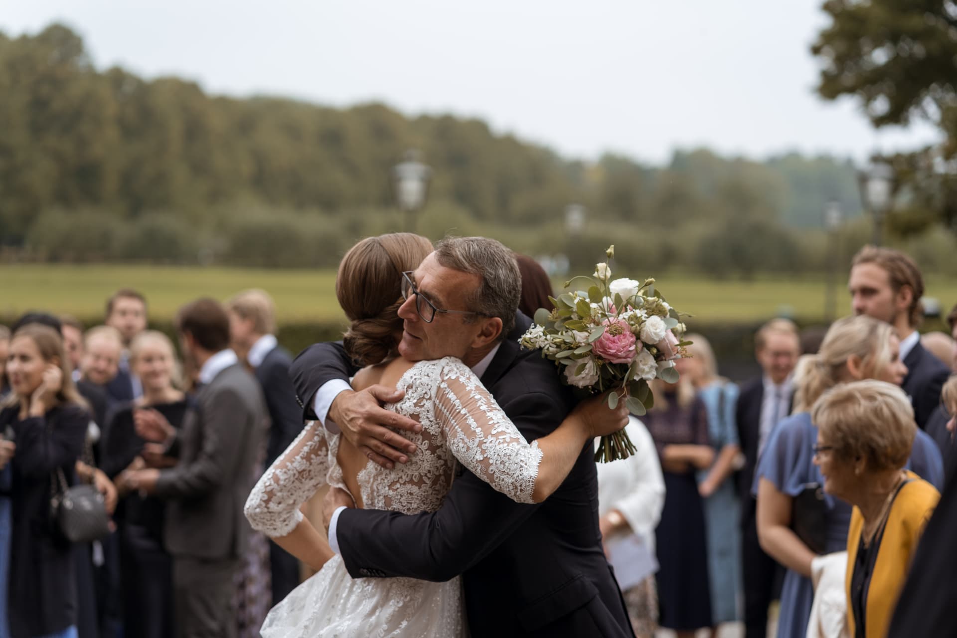 Bruden får en varm kram av sin pappa utanför kyrkan – bröllopsfoto av Mehmet Budak