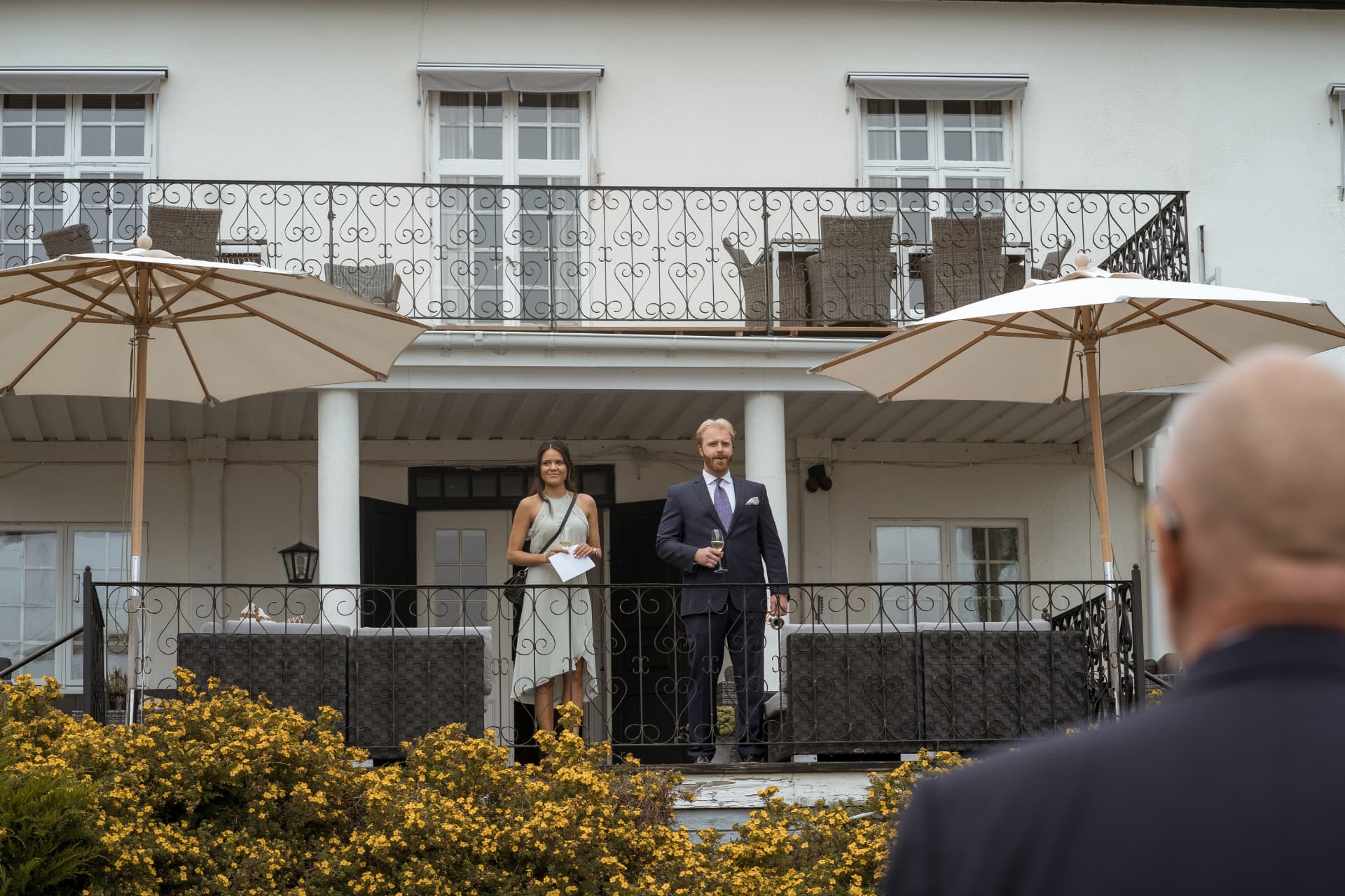Talare välkomnar bröllopsgästerna från Friiberghs Herrgårds terrass – bröllopsfoto av Mehmet Budak