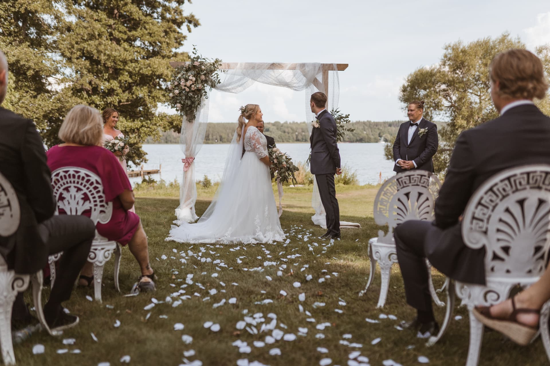 Bruden och brudgummen framför blomsterbågen under vigseln – bröllopsfoto av Mehmet Budak