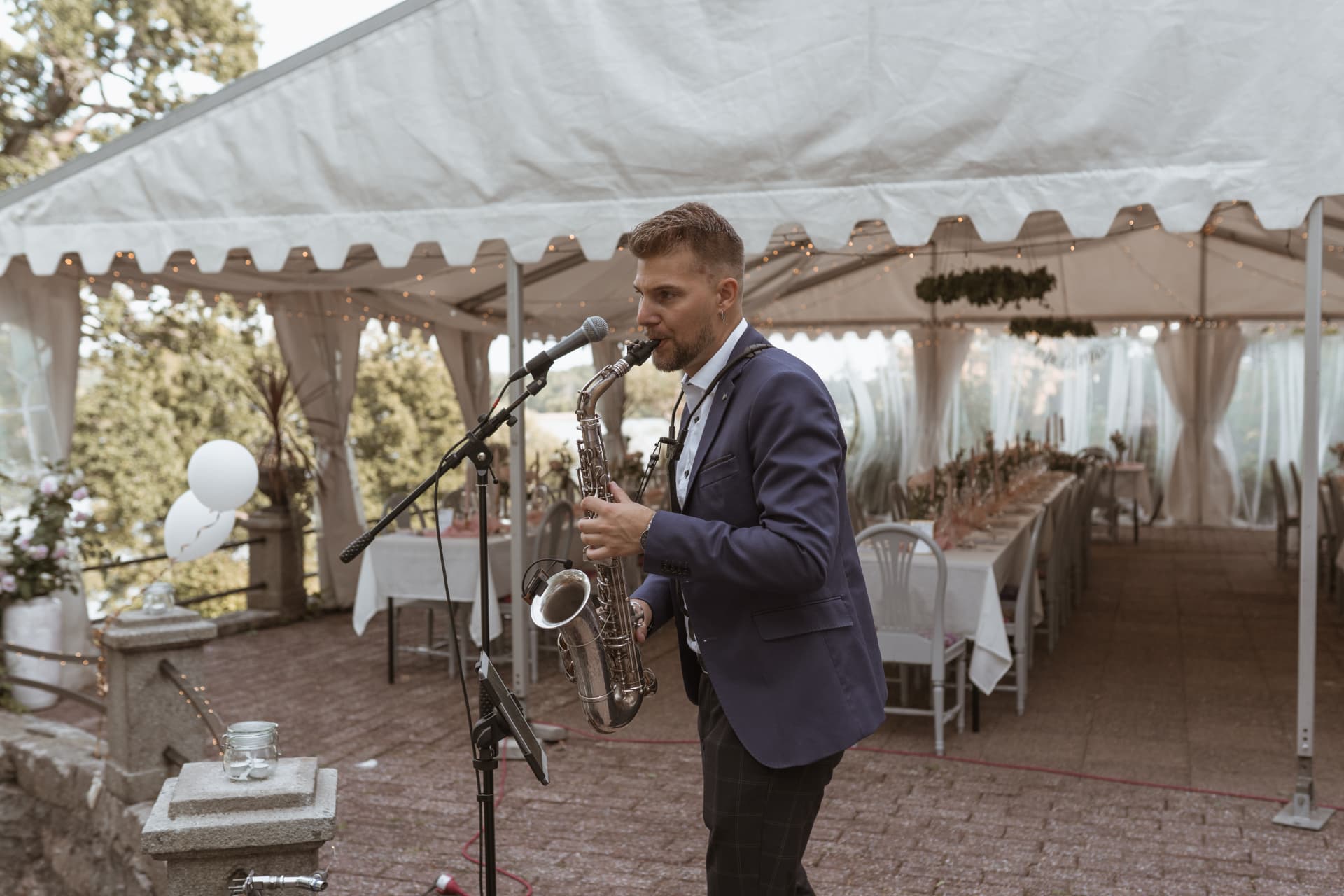 Saxofonist spelar i festtältet inför middagen – bröllopsfoto av Mehmet Budak