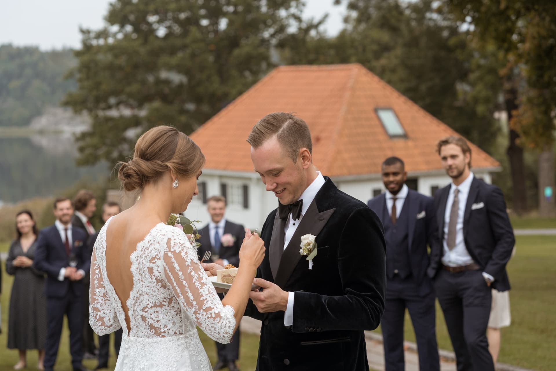 Brudparet smakar bröllopstårtan under minglet – bröllopsfoto av Mehmet Budak