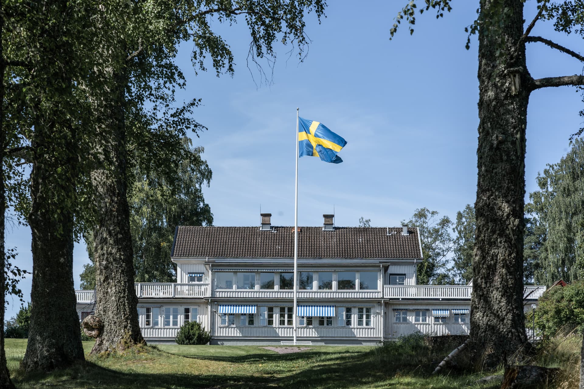Ulvsunda Herrgård i Sunne med svenska flaggan i sommarsol – bröllopsfoto av Mehmet Budak