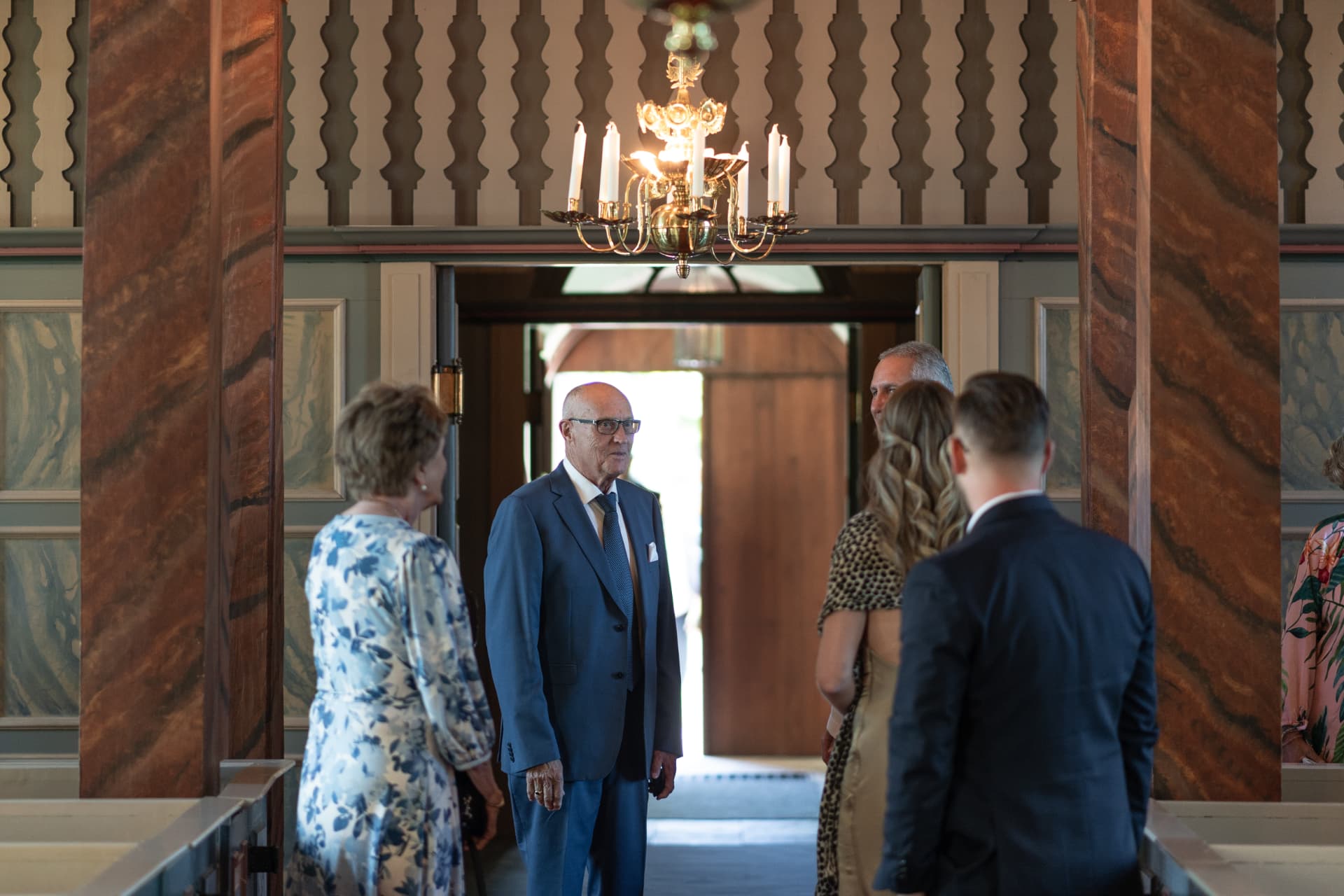 Gästerna anländer till kyrkan under kristallkronan före vigseln – bröllopsfoto av Mehmet Budak