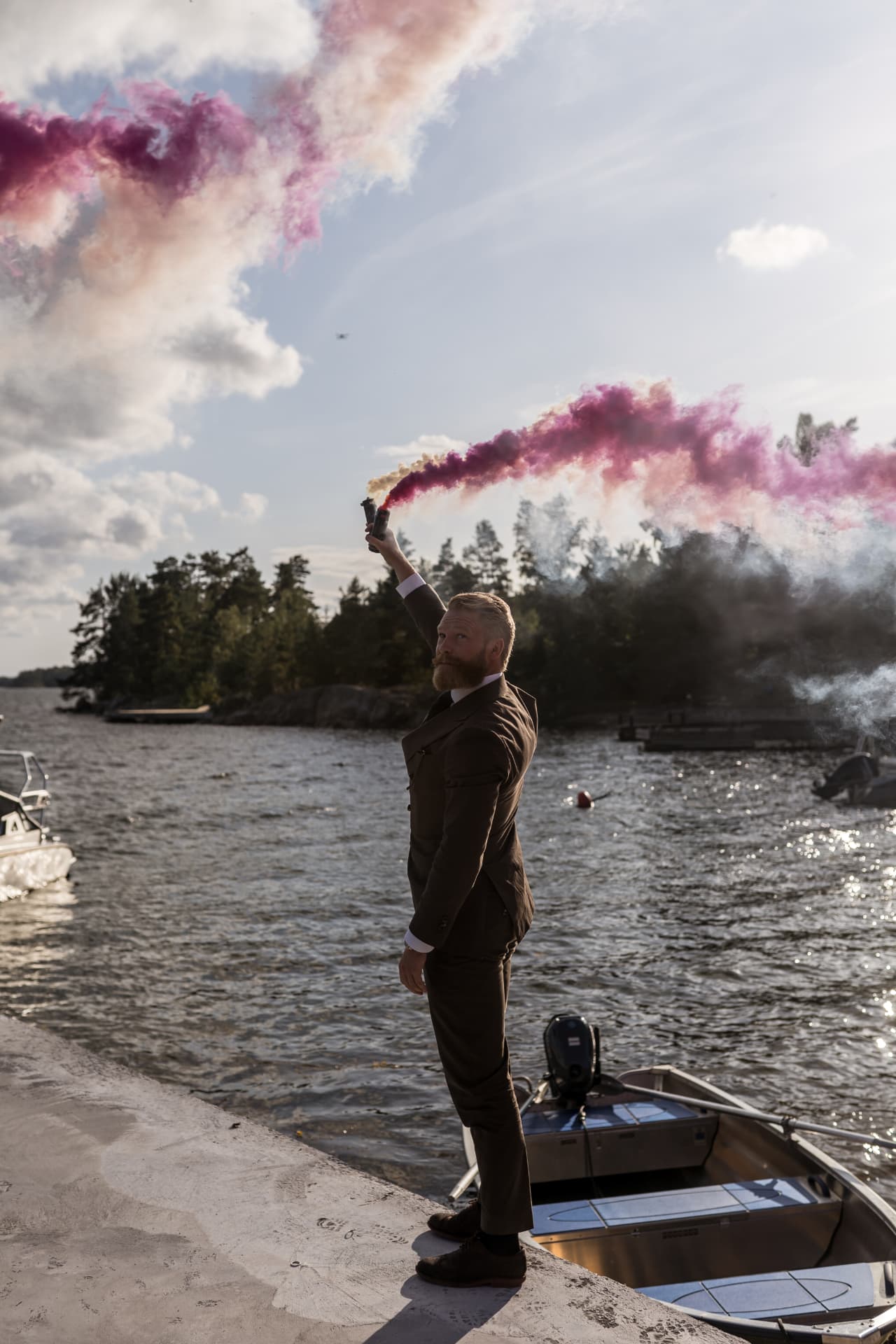 En gäst höjer ett rökbloss på bryggan – bröllopsfoto av Mehmet Budak