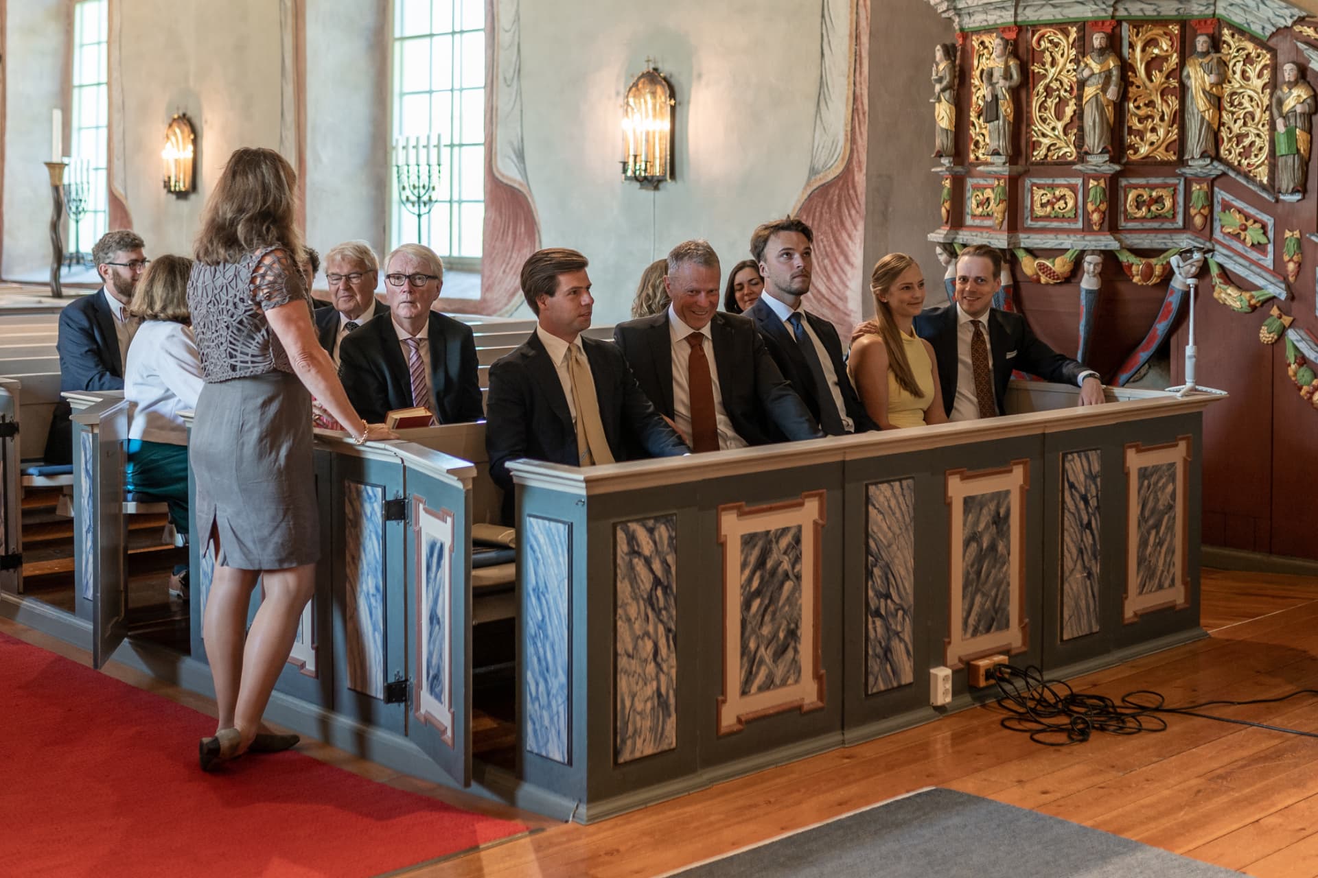 Familj och gäster följer vigseln från kyrkbänkarna – bröllopsfoto av Mehmet Budak