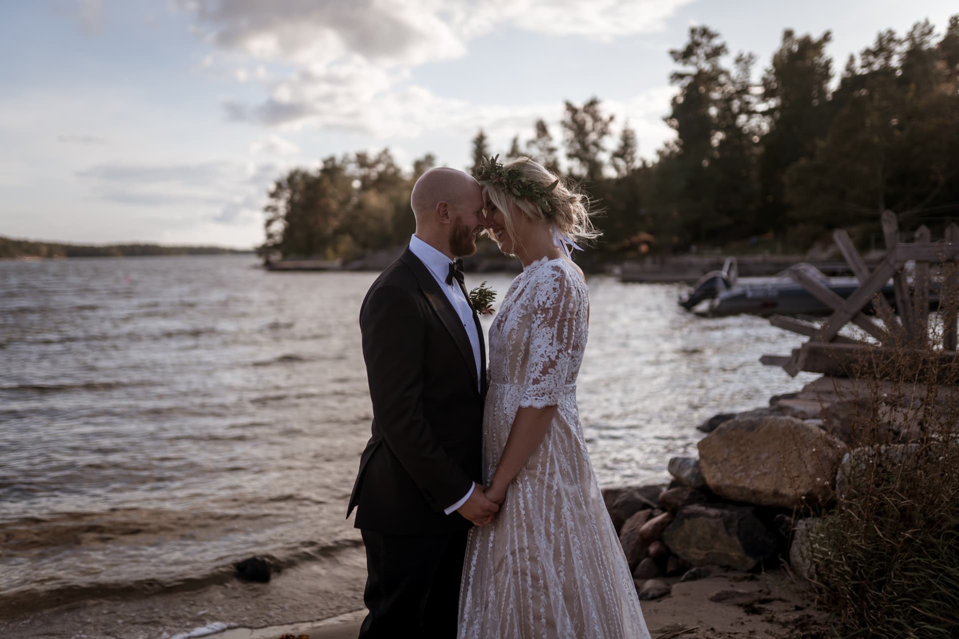 Brudparet håller hand vid stranden i kvällsljus – bröllopsfoto av Mehmet Budak