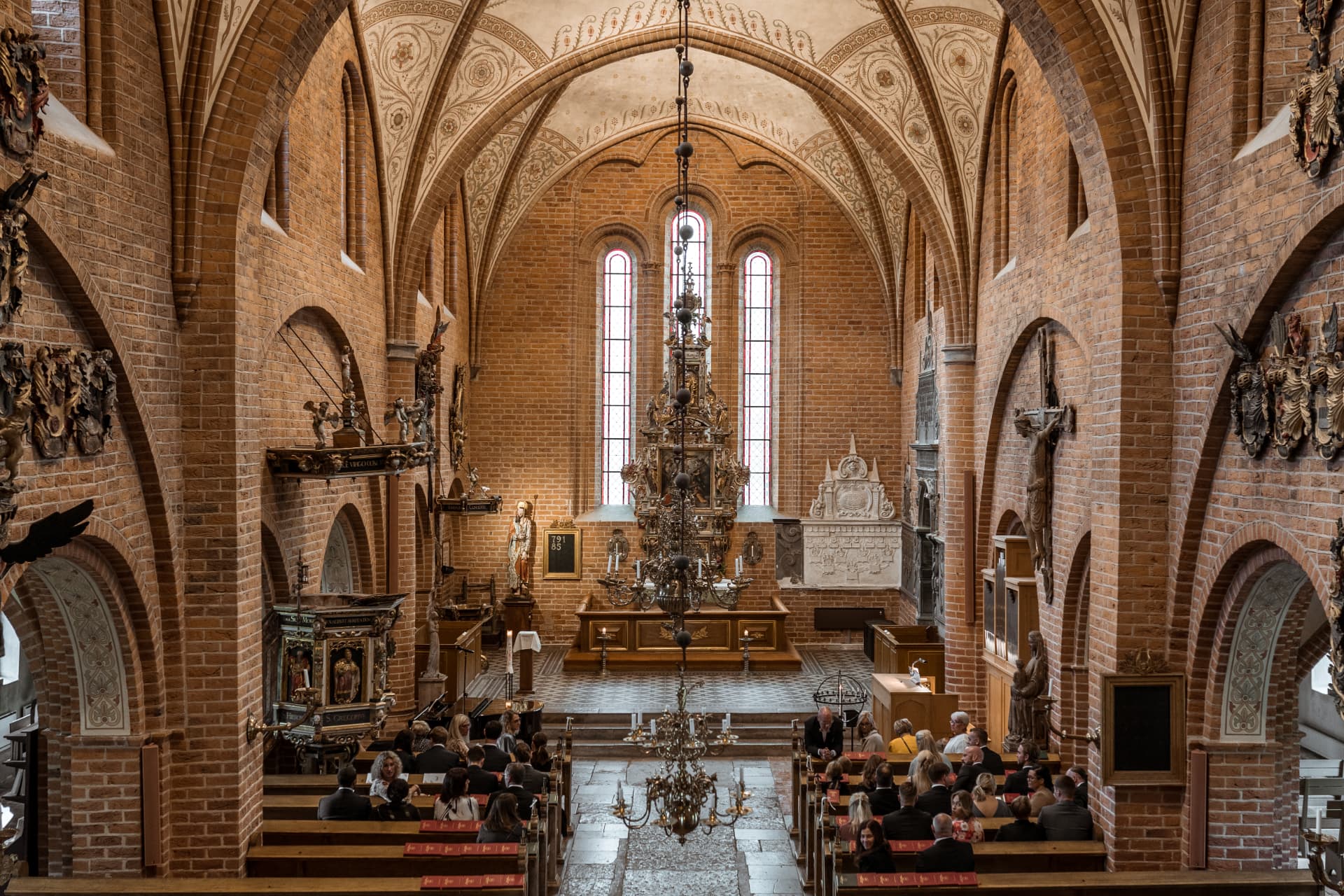 Kyrkorummet med valv och ljuskrona sett från läktaren – bröllopsfoto av Mehmet Budak