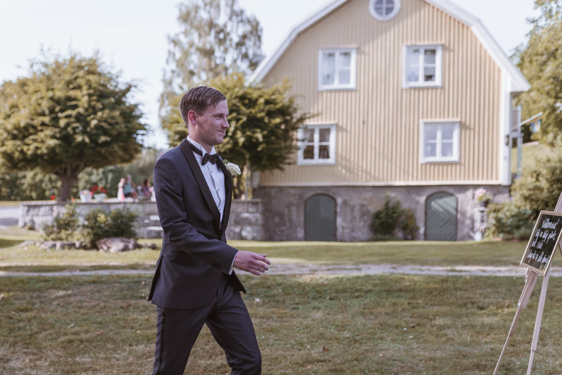 Brudgummen går mot vigselplatsen framför den gula byggnaden – bröllopsfoto av Mehmet Budak