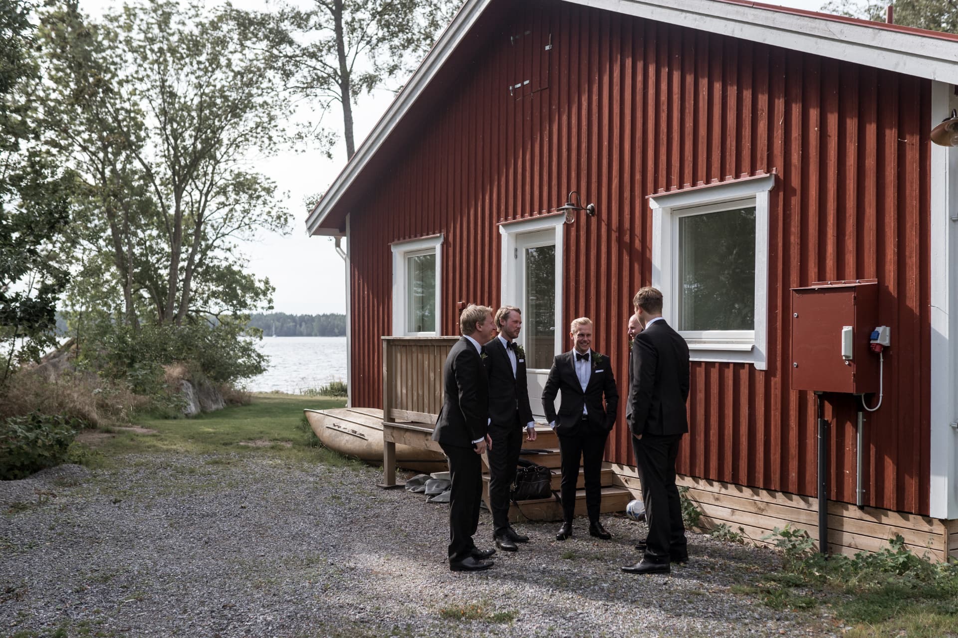 Brudgummen och vännerna utanför stugan vid vattnet – bröllopsfoto av Mehmet Budak